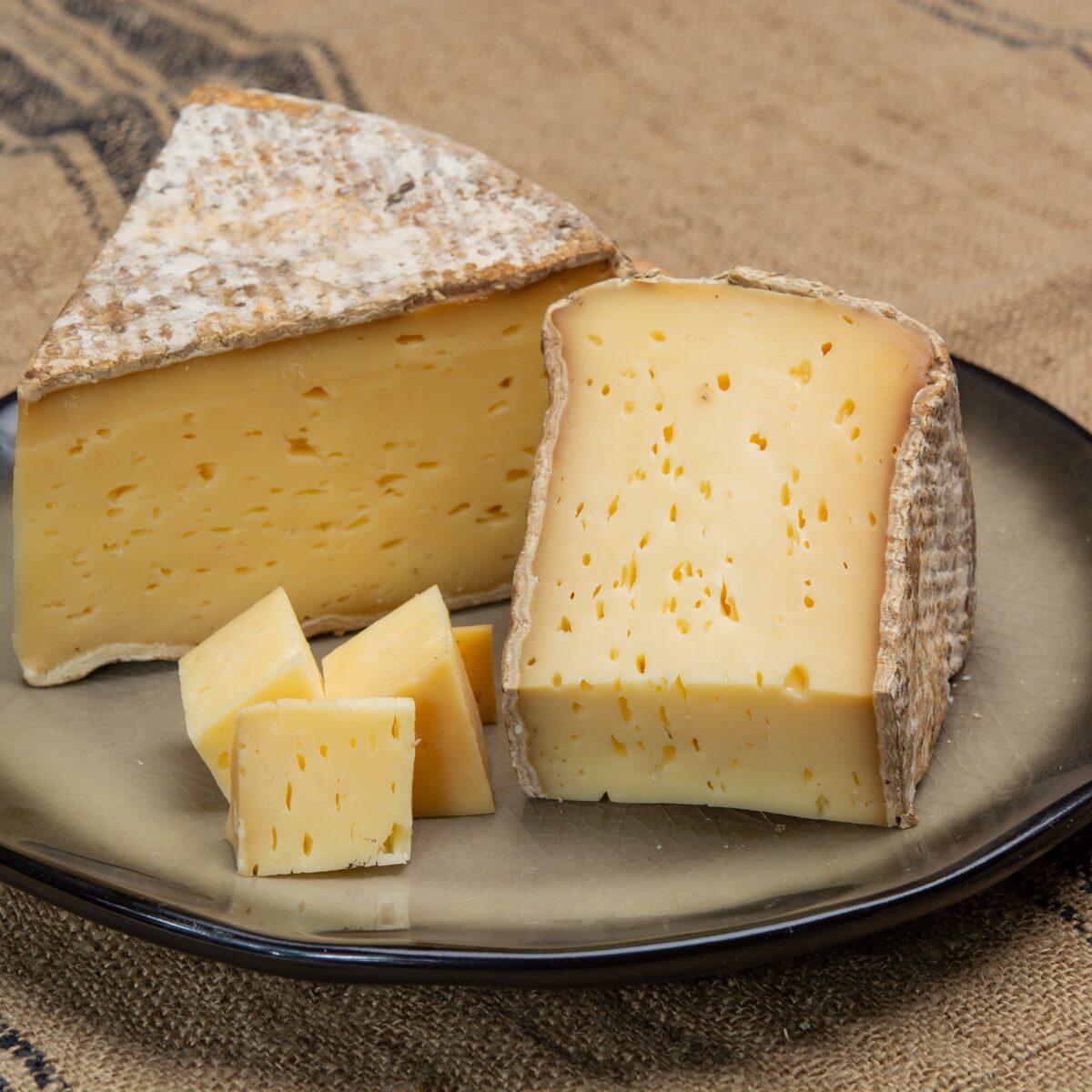 Pieces of cheese tomme de montagne or tomme de savoie made from cow milk in French Alps, France, close up